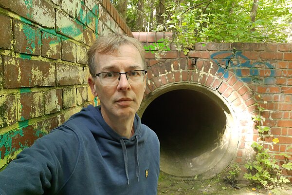 Mark Ridyard in front of a sewage outfall pipe into the Ouseburn
