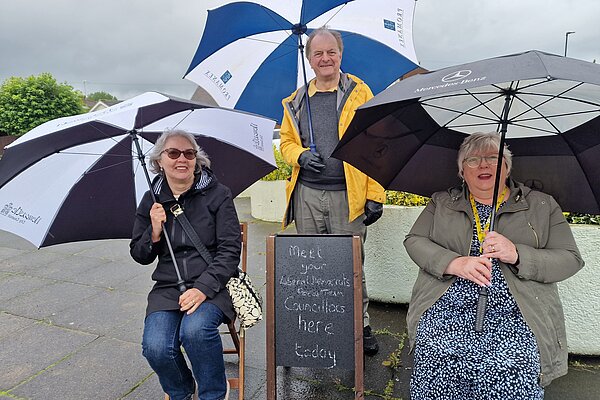 The Focus Team holding umbrellas at a rainy Street Surgery