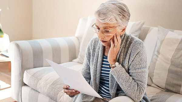 A lady looking at her bills.