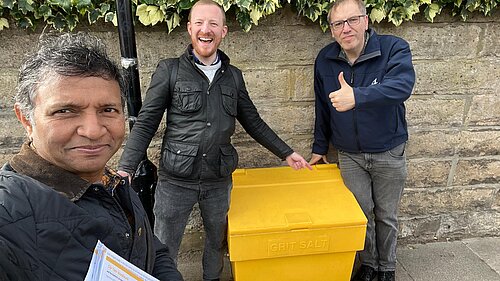 Left to right: Tahir, Cllr Colin and Cllr Tom standing outside newly installed grit bin.