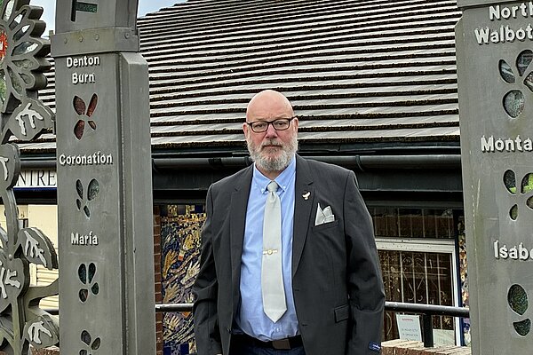 Stephen Kelly stood in front of entrance arch of The Grange