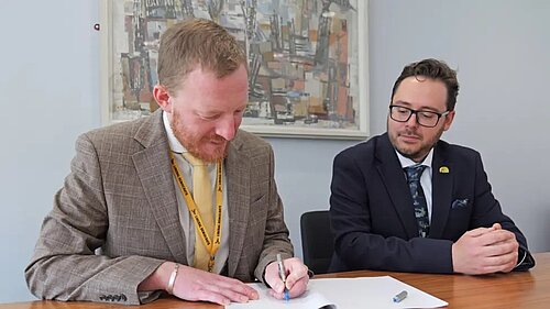 Councillors Colin Ferguson and Nick Hartley signing co-operation agreement