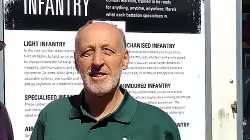 Cllr David Down stood in front of Armed Forces Covenant banner