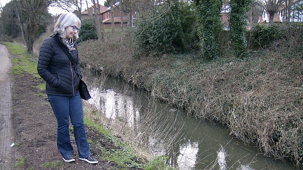 Pauline inspects the dirty water in the Ouseburn