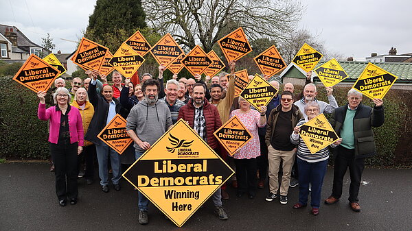 Newcastle Liberal Democrat activists holding diamond posters